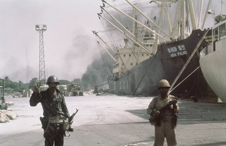 Iraqi forward troops stand guard over shipping at the dockside in occupied Khorramshahr, Iran on Oct. 7, 1980. (AP Photo)