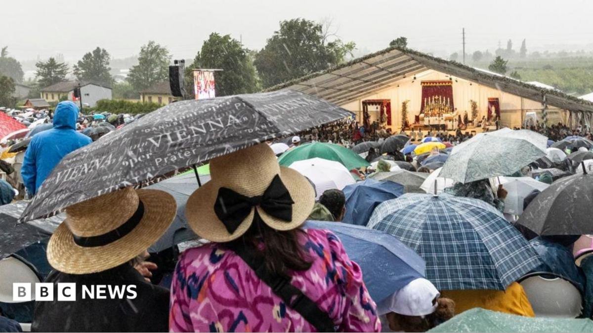 Worshippers stand under umbrellas amidst heavy rain during the episcopal consecration of Catholic priests as part of a pontifical Mass organized by the Society of Saint Pius X in Econe, near Sion, Switzerland, 1 July