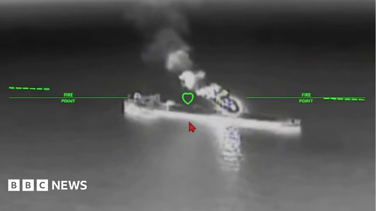 A still image of an oil tanker under attack from a drone in a black and while nighttime image