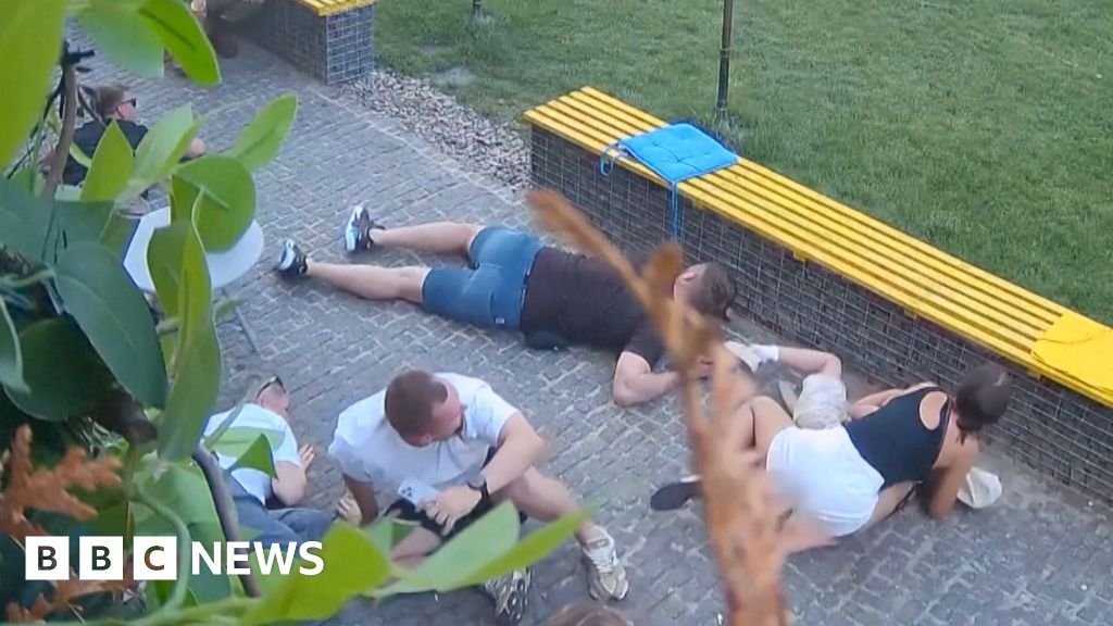 At least six people crouched on the floor as they take shelter from attack neaby