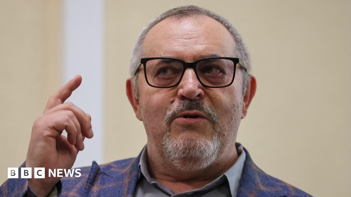 Boris Nadezhdin, who has short grey hair, wears a colourful blazer and glasses in court in Dolgoprudny, Moscow region, last month. He is pointing upwards with his right index finger.