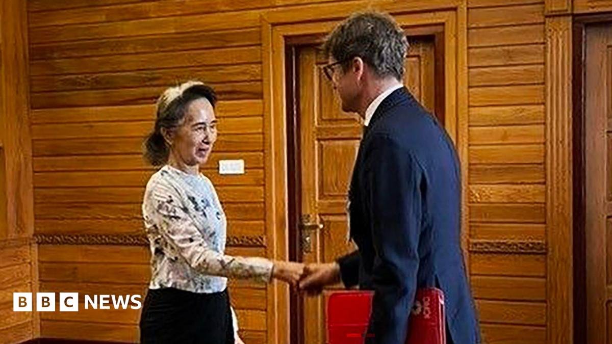 Former Myanmar president Aung San Suu Kyi shakes hands with  Arnaud de Baecque, resident representative of the International Committee of the Red Cross (ICRC)