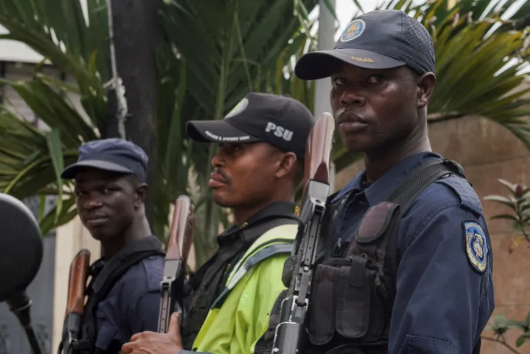 Security guards stand outside a building in Marshall, a small beach town near Roberts International Airport, as deportees from the United States arrive in Liberia, August 20, 2026. REUTERS/Carielle Doe REFILE - CORRECTING LOCATION FROM "IN HARBEL, NEAR MONROVIA" TO "IN MARSHALL".
