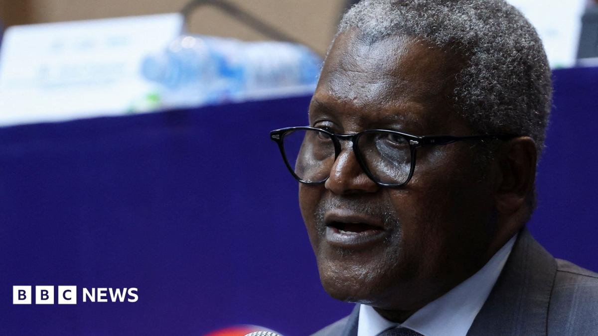 A close-up photo of Aliko Dangote. He is wearing glasses and a suit, with short, salt and pepper hair.