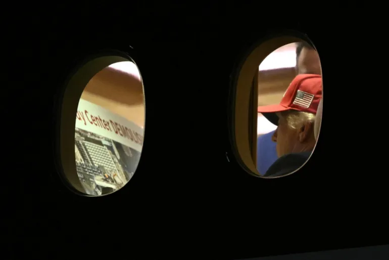 US President Donald Trump is seen aboard Air Force One checking a Kennedy Center large printout after landing at Joint Base Andrews, Maryland on September 16, 2026. Trump, who is returning from Gastonia, North Carolina after campaigning for Republican US Senate candidate Michael Whatley, threatened on September 15, 2026 to keep the Kennedy Center closed for good after a judge ruled his name cannot be added onto the famed arts institution's facade. (Photo by Brendan SMIALOWSKI / AFP)